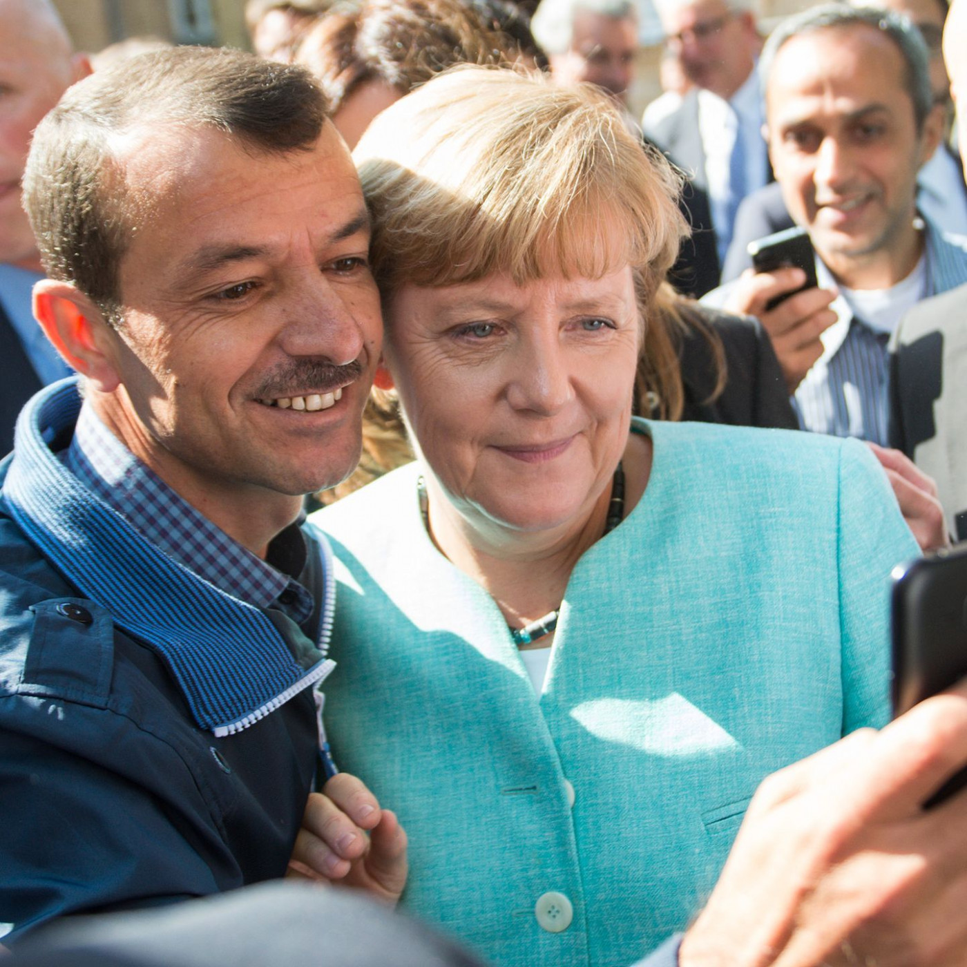 Merkel mit Geflüchteten am Tisch - zehn Jahre nach 2015