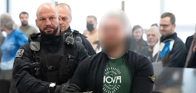 Unter Applaus wird der mutmaßliche Chef der „Hammerbande“ zur Anklagebank geführt